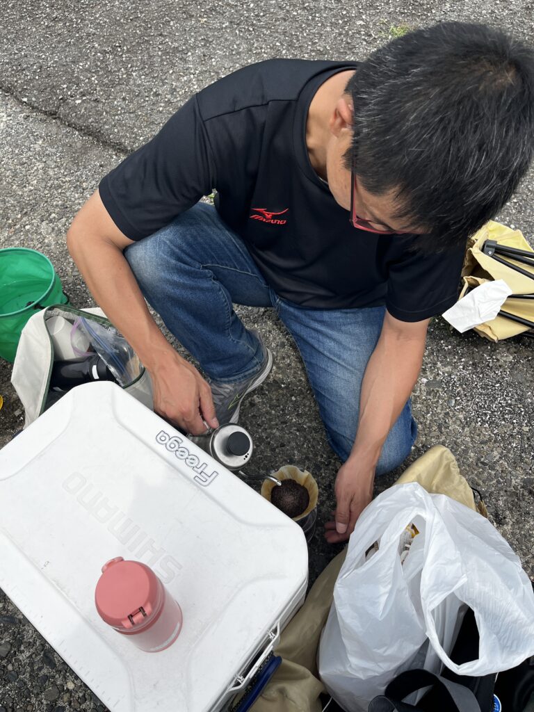 海辺の堤防でコーヒーをいれる龍太さん