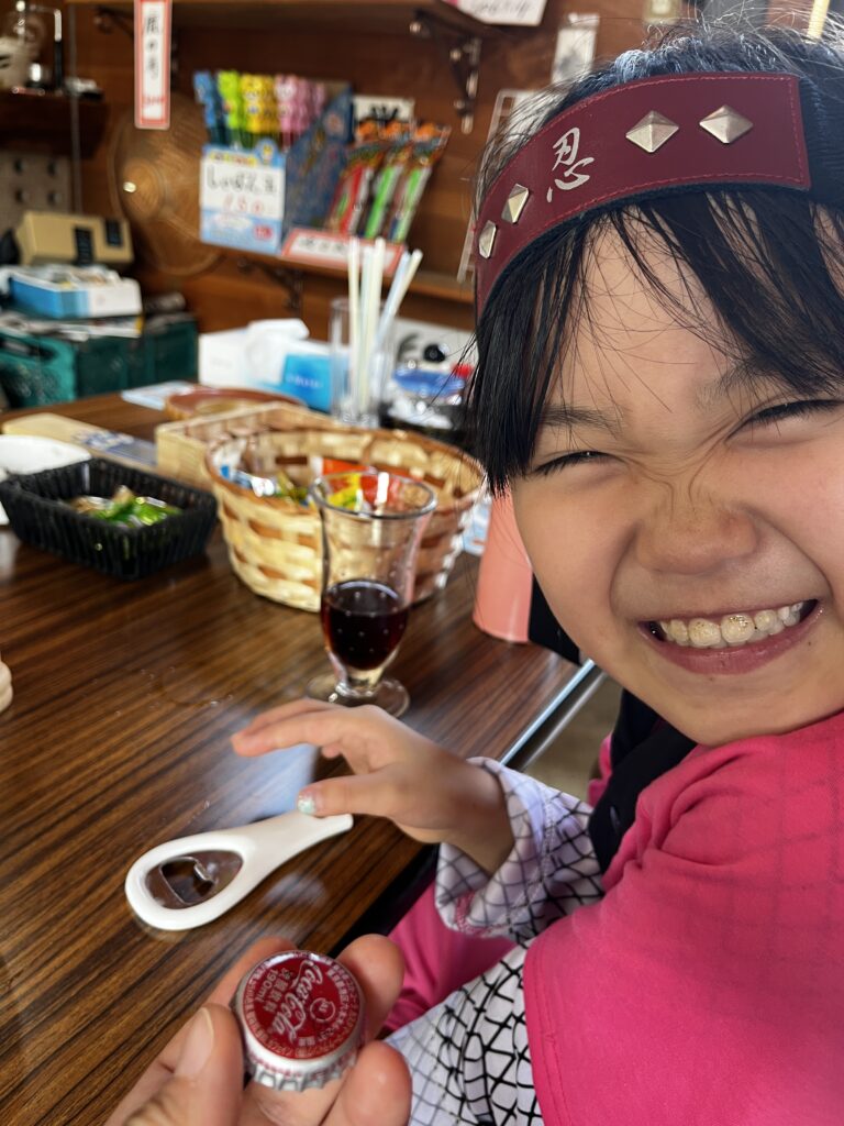 瓶入りコーラを嬉しそうに飲む娘