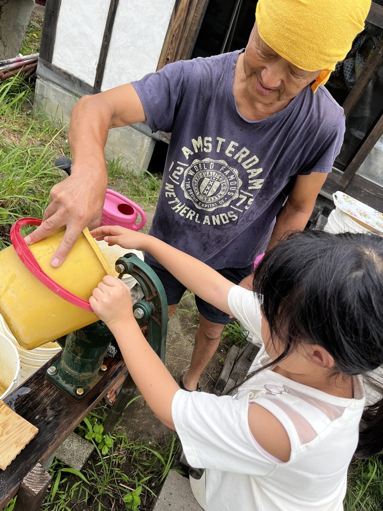 井戸に呼水を入れる様子